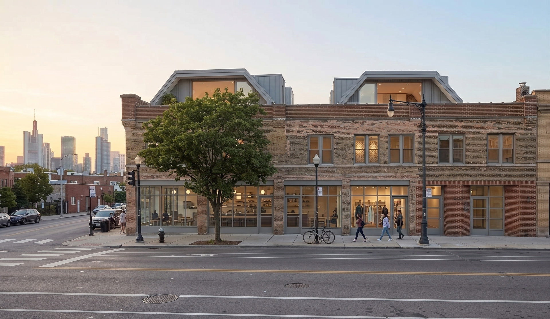 Modern rooftop homes with angular metal roofs and dormer windows added above a restored brick warehouse on a city street